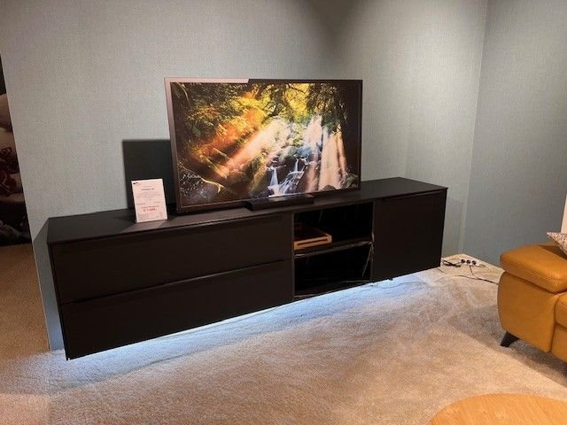 schwarzes Lowboard mit Griffleiste und Beleuchtung