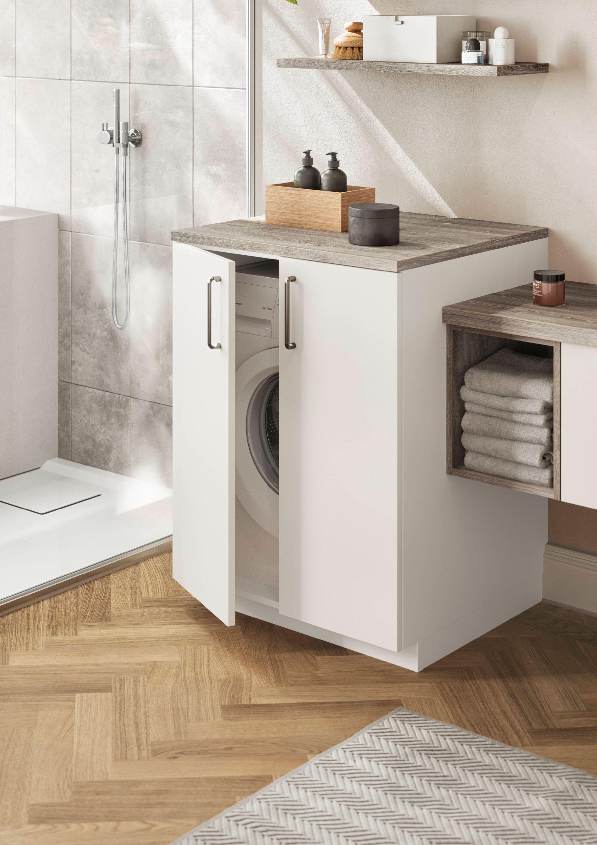 Badezimmermöbel mit integriertem Waschmaschinenfach, modernen weißen Türen und einer rustikalen Arbeitsplatte.