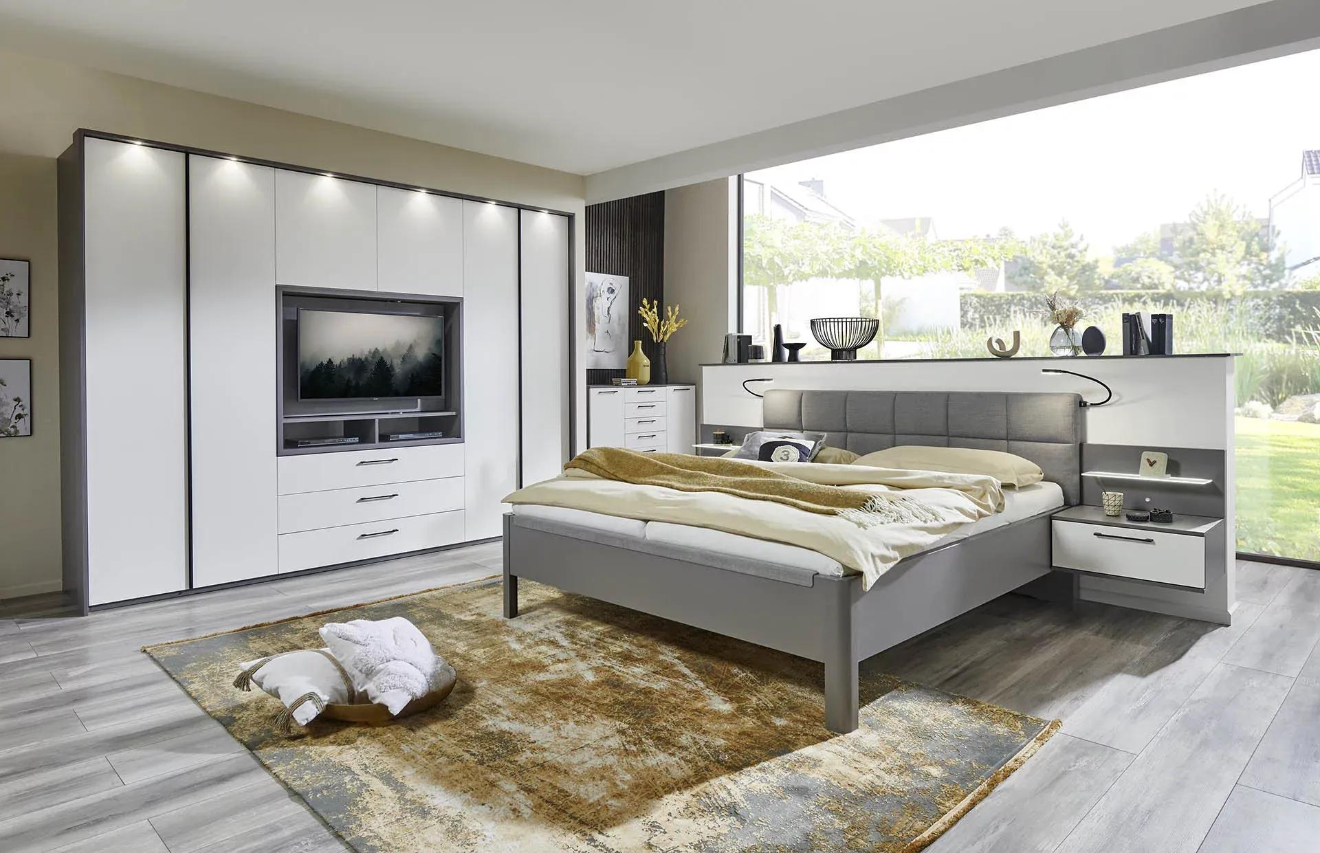 Schlafzimmer mit grauen Akzenten und einer modernen Kombination aus Schrank und TV-Wand.