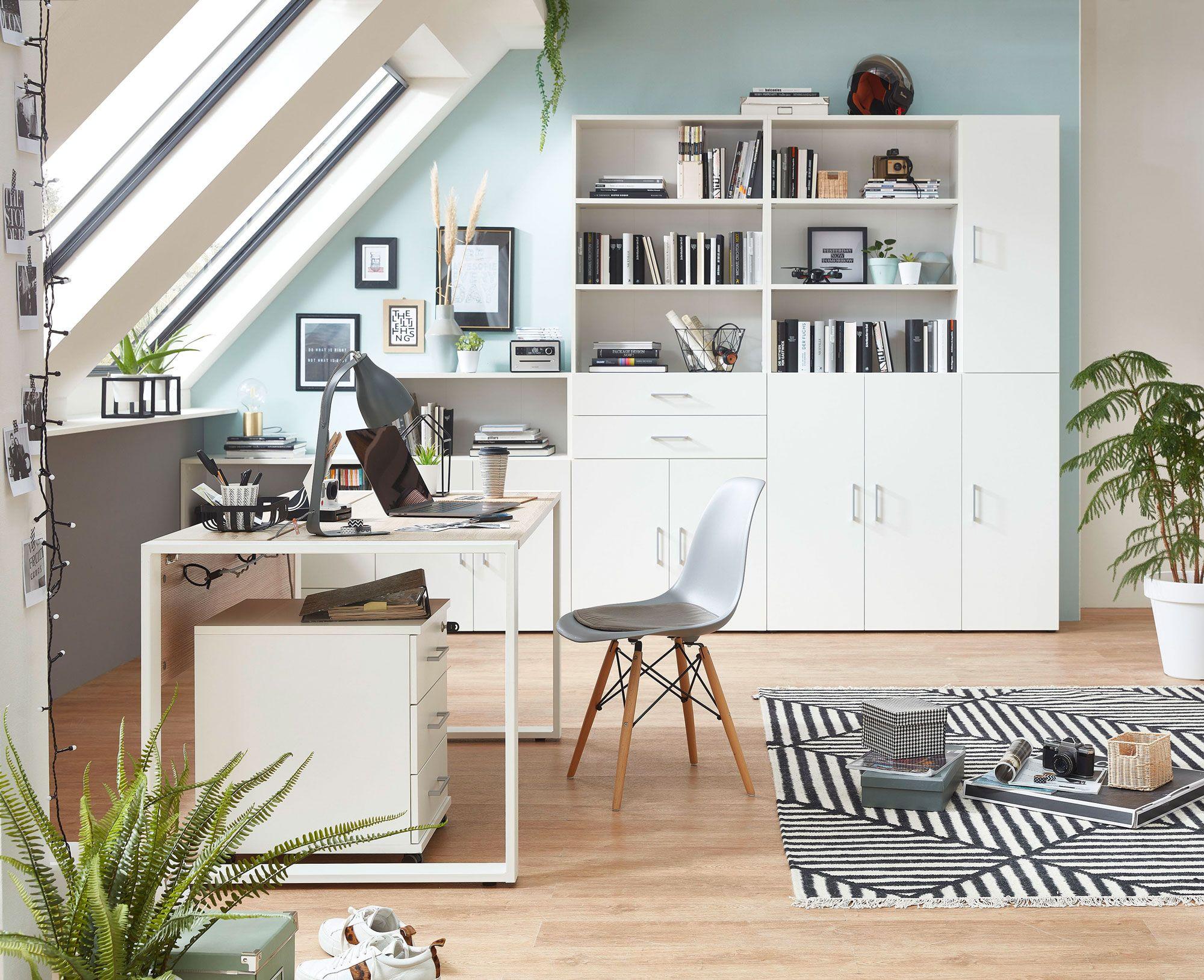 Helles Dachgeschoss-Homeoffice mit großem Schreibtisch, Regalsystemen und weißen Möbeln. Viel Tageslicht und Dekorationen sorgen für eine inspirierende Atmosphäre.