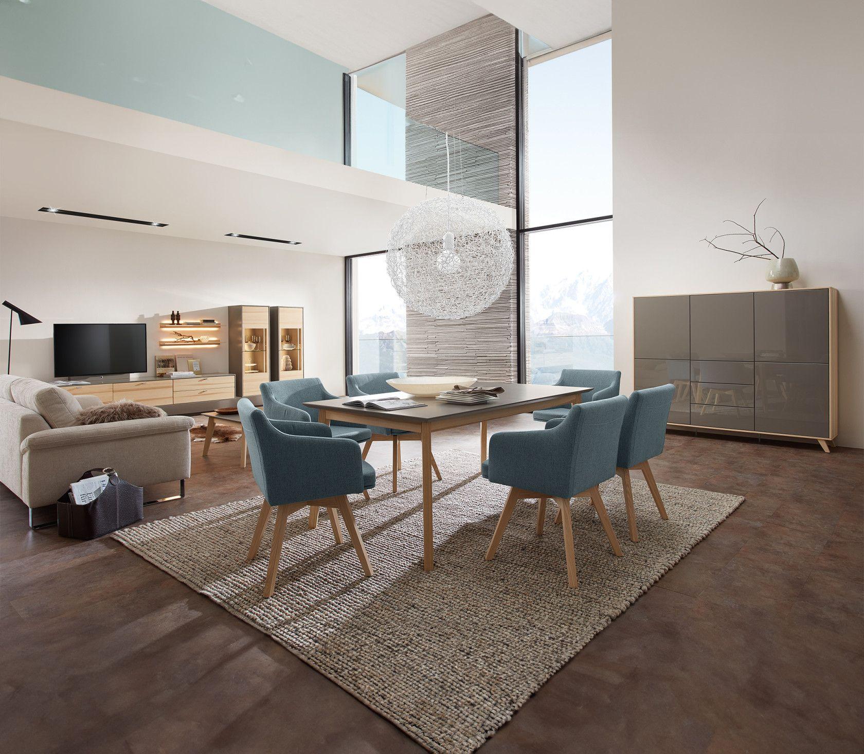 Elegantes Esszimmer mit blauen Stühlen, einem großen Fenster und moderner Einrichtung.