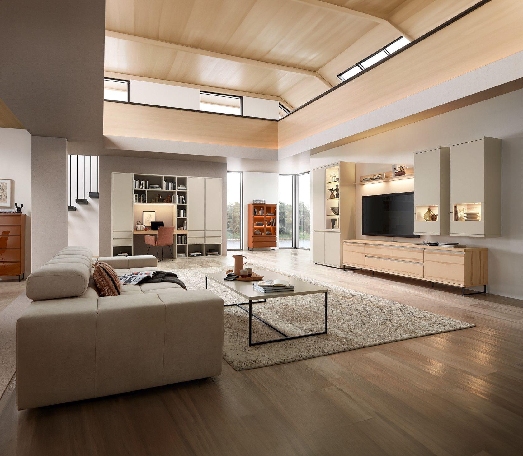 Offener Wohnbereich mit TV-Wand, einem eleganten Sofa und stilvoller Beleuchtung.